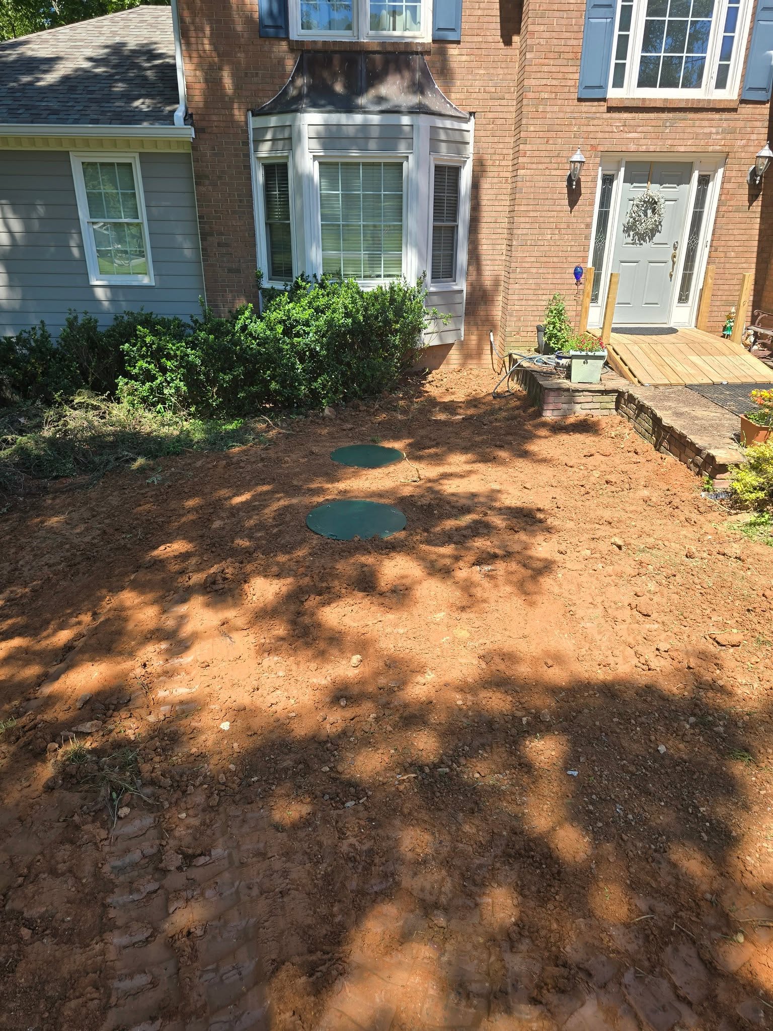 After — same yard backfilled with tank lids at grade